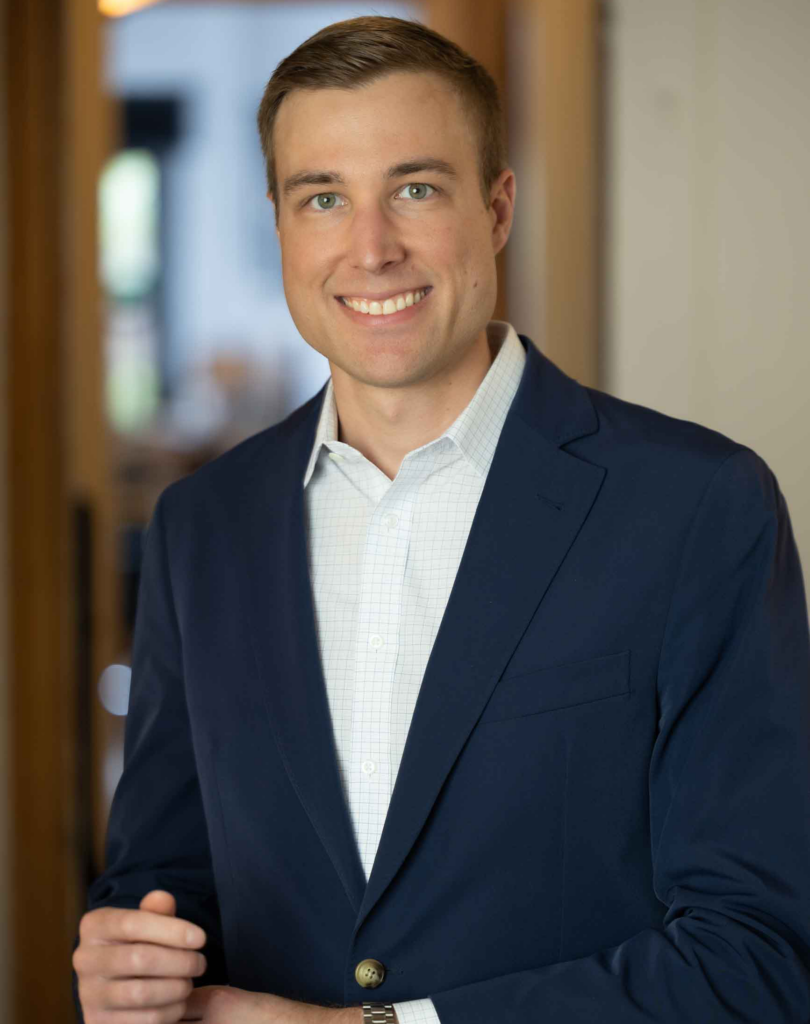 Man in suit, smiling at the camera, professional headshot